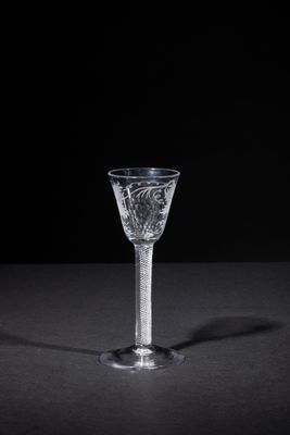 a close up of a wine glass on a table with a black background