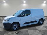 Une camionnette blanche est garée dans une pièce dont le sol est en damier.