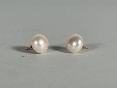 a pair of pearl earrings on a white surface