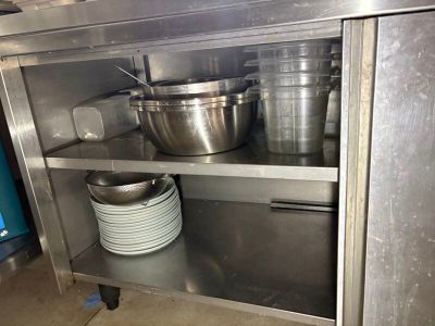 many pots and pans on the shelf in the kitchen