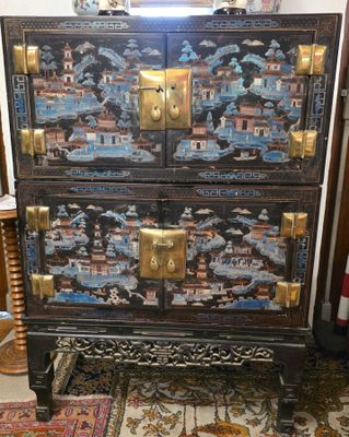 une commode noire et dorée dans un salon