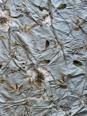 a close up of a bed with a floral design on it