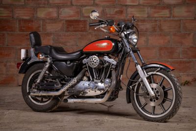 a red motorcycle parked in front of a brick wall