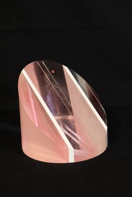 a picture of a pink and white glass object on a black background
