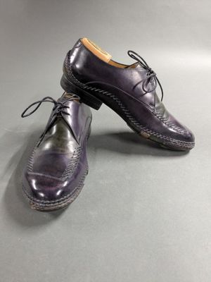a pair of purple shoes on a gray surface