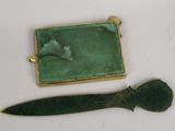 a small knife and a small green object on a table