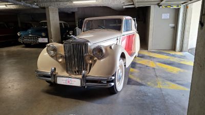 a old car parked in a parking garage next to other cars