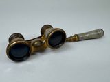 pair of antique brass goggles with black lenses on a white surface