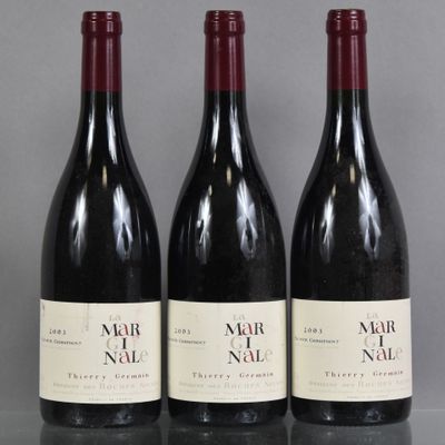 trois bouteilles de vin sont alignées sur une table