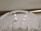 a clear glass bowl on a table with a mirror in the background
