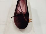 quelqu'un porte une paire de chaussures posées sur une boîte