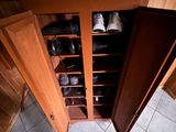 une armoire en bois contenant de nombreuses paires de chaussures