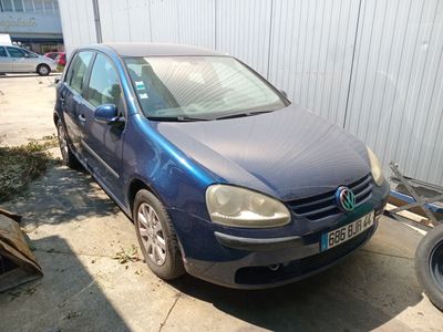 a blue car that is parked next to a trailer