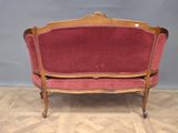 a red couch that is sitting on a wooden floor