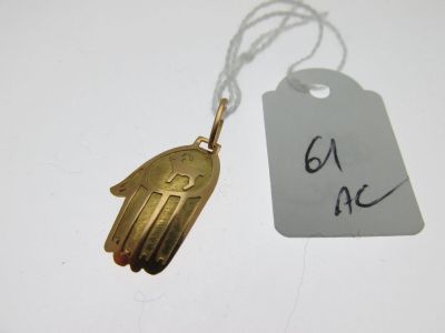 une petite main en or à laquelle est attachée une étiquette