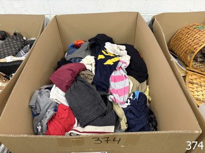 a cardboard box full of clothes and a basket full of clothes