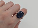 la main d'une femme tenant une bague sertie d'une pierre noire