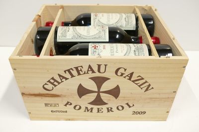 bouteilles de vin dans un coffret en bois sur une surface blanche