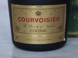 a bottle of cognac next to a canister of cognac