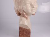 a statue of a woman that is sitting on a block