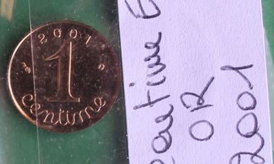 une pièce d'un penny posée sur un bout de papier auquel est attachée une note