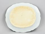 a white plate with a pie on it on a gray surface