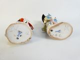 two small figurines of people sitting on top of each other