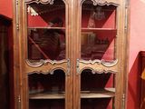 un meuble en bois avec des portes en verre dans une pièce