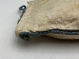 a small bag with a rope on it sitting on a table