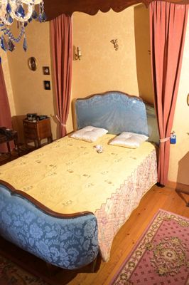 un lit surmonté d'un baldaquin, dans une chambre