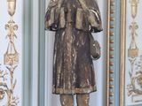 une statue représentant un homme debout devant un miroir