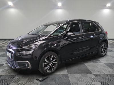 une citrole noire garée sur un sol en damier dans un garage