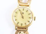 une montre-bracelet en or avec une chaîne autour d'elle