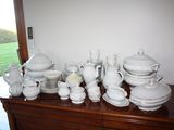 a lot of white dishes and cups on a dresser