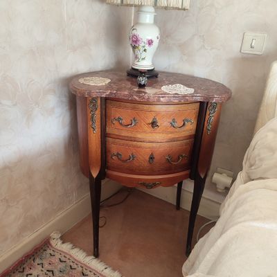 une table sur laquelle est posée une lampe, à côté d'un lit