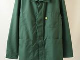 the green jacket is hanging on a hanger on the wall