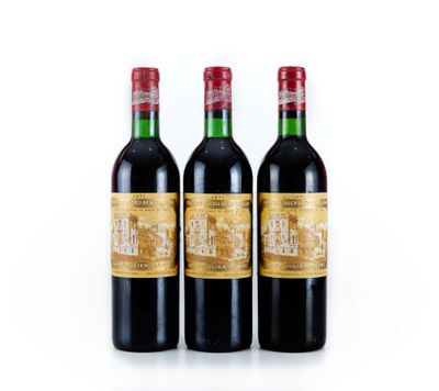 trois bouteilles de vin rouge posées l'une à côté de l'autre sur une surface blanche