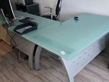 a glass desk with a computer on it in a living room