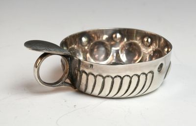 une tasse en argent posée sur une table, avec une cuillère à l'intérieur