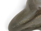a bronze sculpture of a dog on a white surface