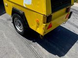 un camion jaune garé sur le bord de la route
