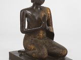 une image représentant la statue d'une personne assise sur une estrade