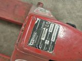 a close up of a red gas pump on a cement floor