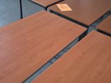 quatre tables en bois dans une pièce aux murs blancs