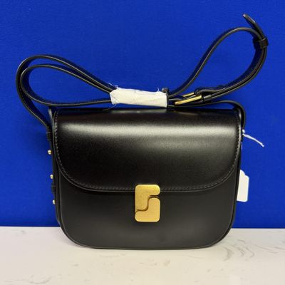 un sac en cuir noir orné d'une boucle dorée sur le devant