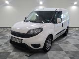 la camionnette blanche est garée dans une grande pièce au sol en damier