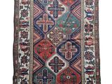 un tapis ancien présentant un motif multicolore sur fond blanc