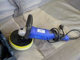 a blue polisher sitting on the floor next to a tool box
