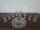 des bouteilles et des verres posés sur une table sur laquelle se trouve un vase