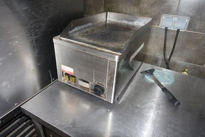 un plan de travail en acier inoxydable dans une cuisine professionnelle, sur lequel est posé un grille-pain